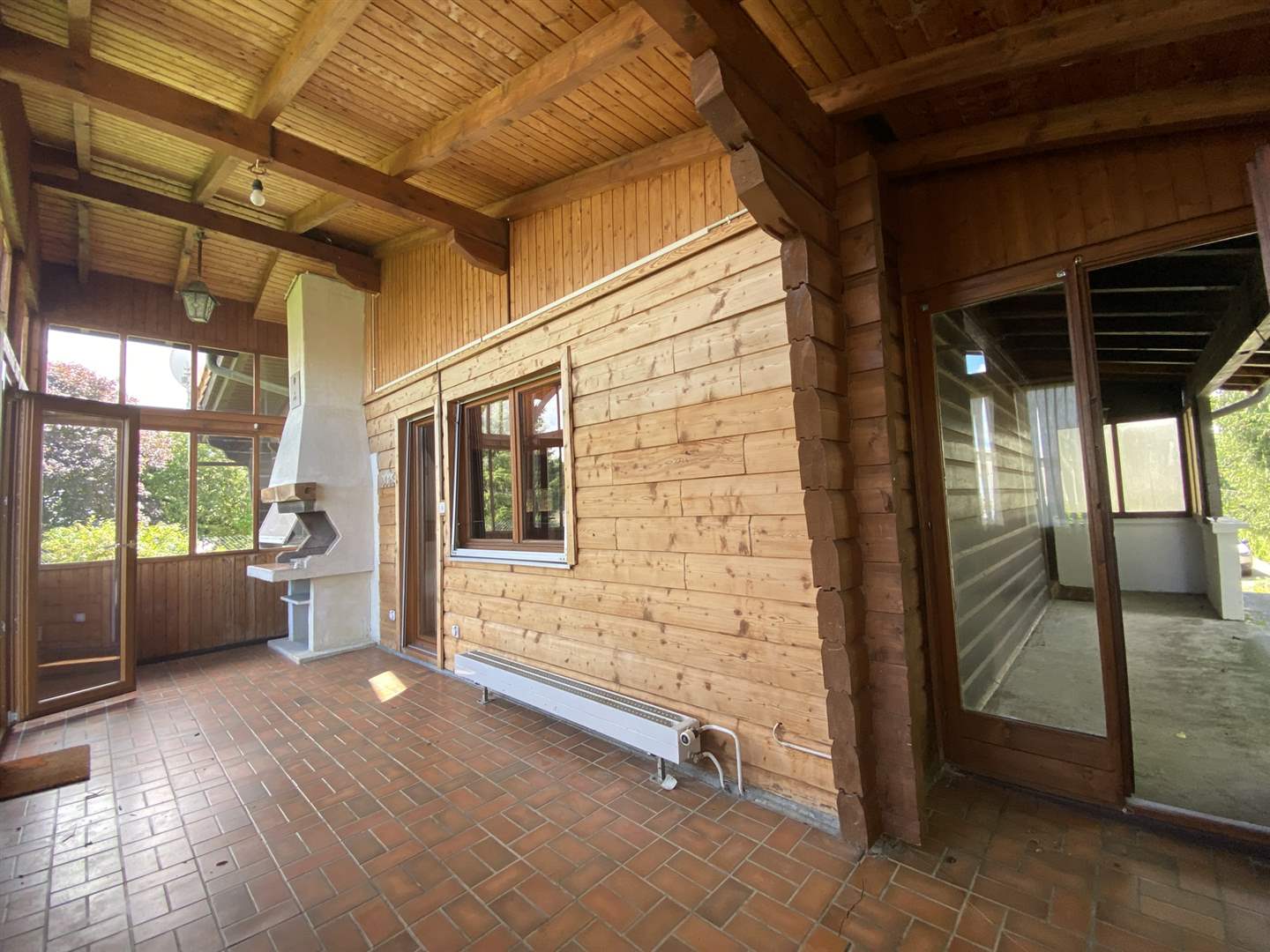 Überdachte Holzterrasse mit Kamin