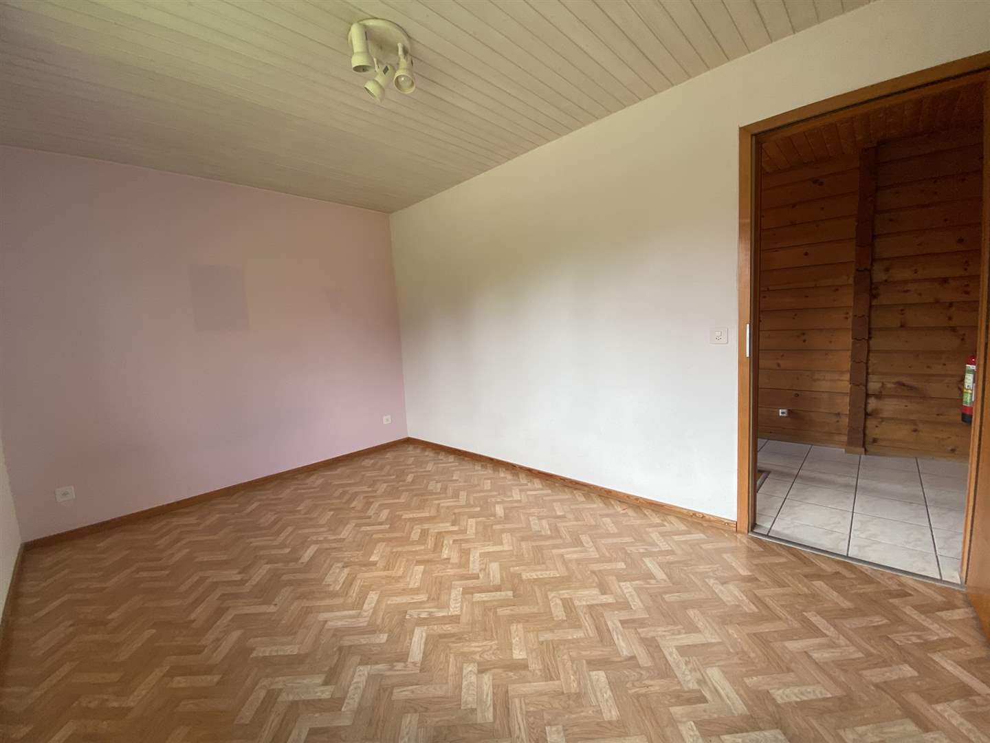 Leerer Raum mit Parkettboden und Holzanschluss
