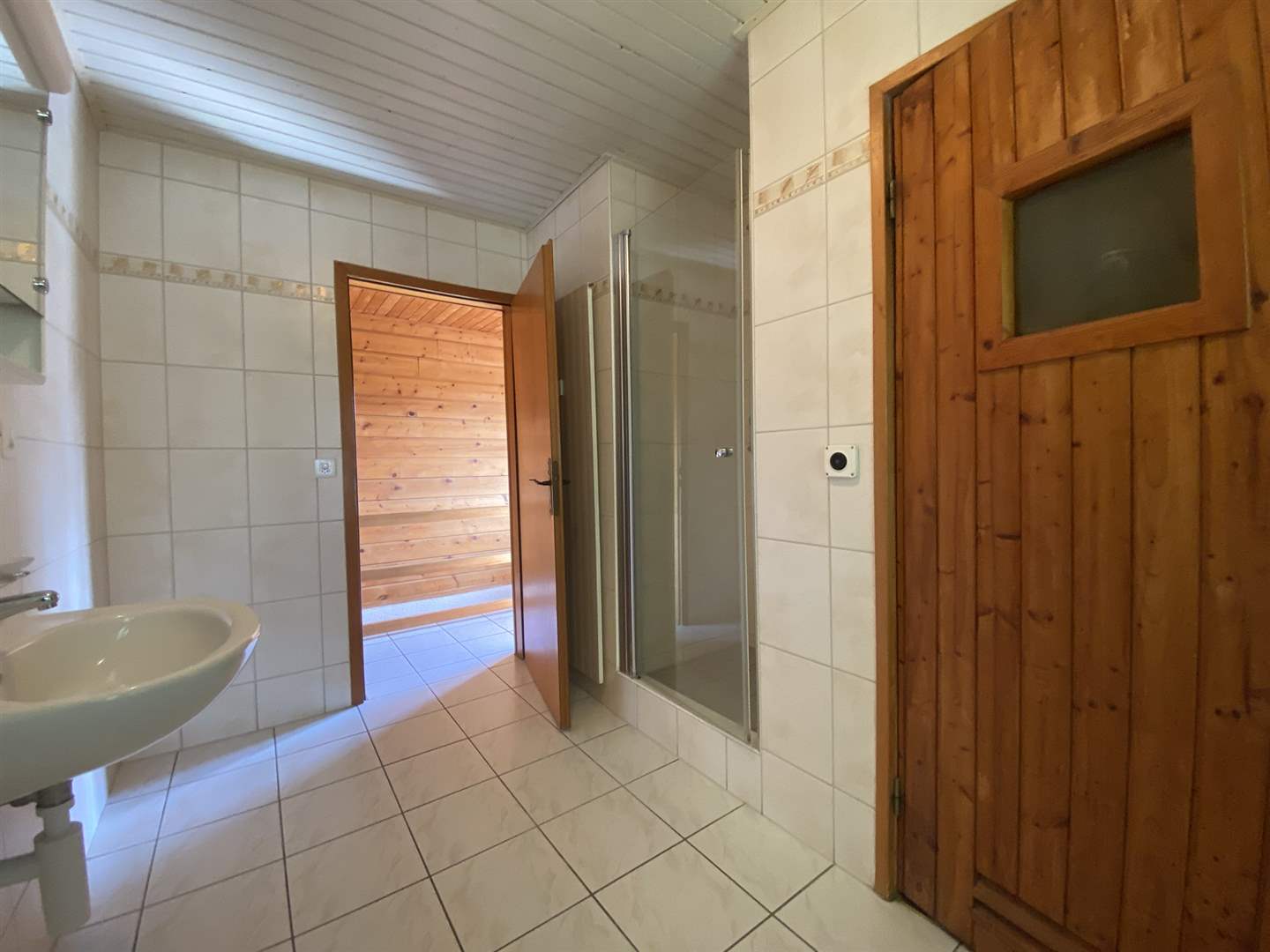 Badezimmer mit Dusche und Holztüren