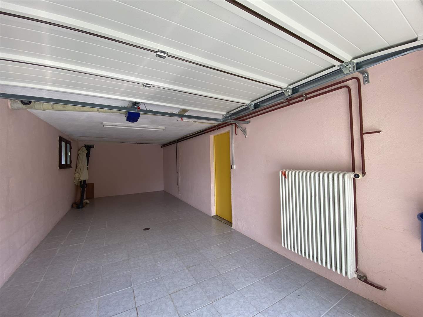 Garage mit gefliestem Boden und Heizkörper