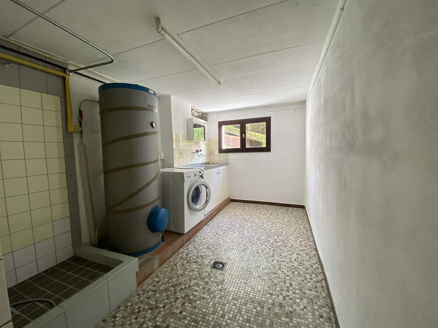 Hauswirtschaftsraum mit Warmwasserspeicher und Waschmaschine