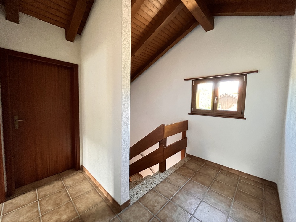 Treppenhaus mit Holzgeländer und Dachschräge