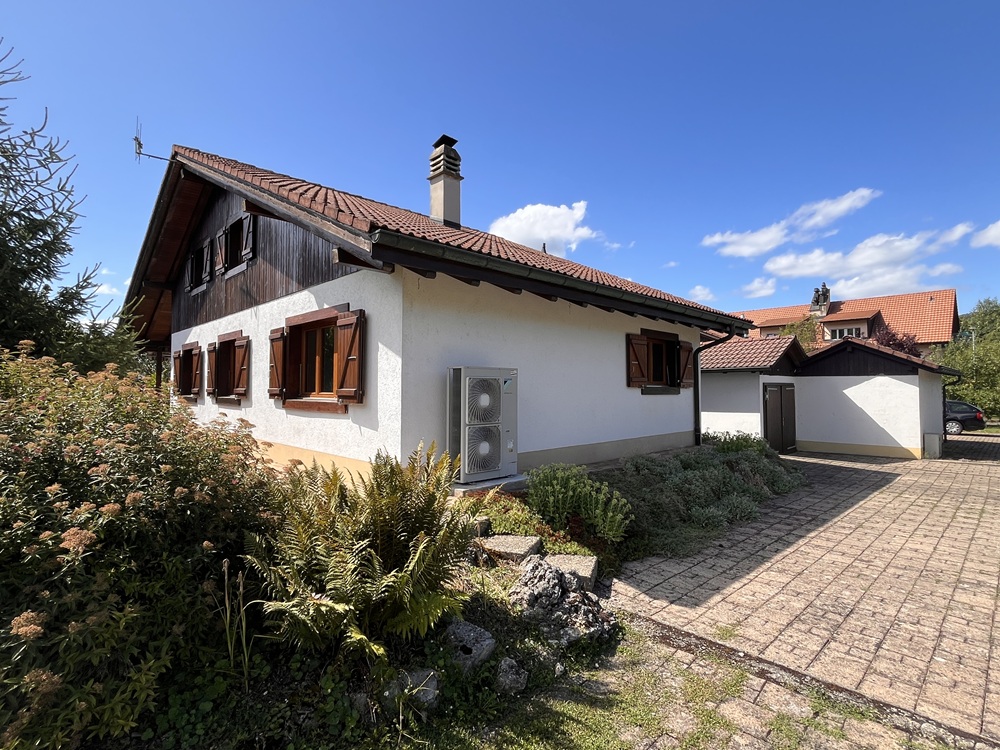 Außenansicht eines Einfamilienhauses mit Garten und Nebengebäude