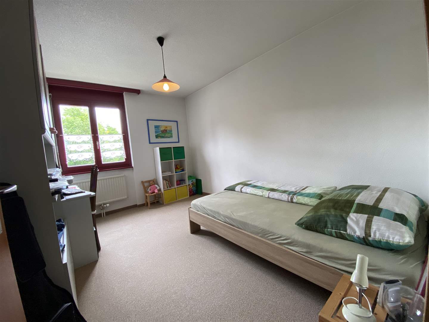 Schlafzimmer mit Einzelbett und Kinderregal