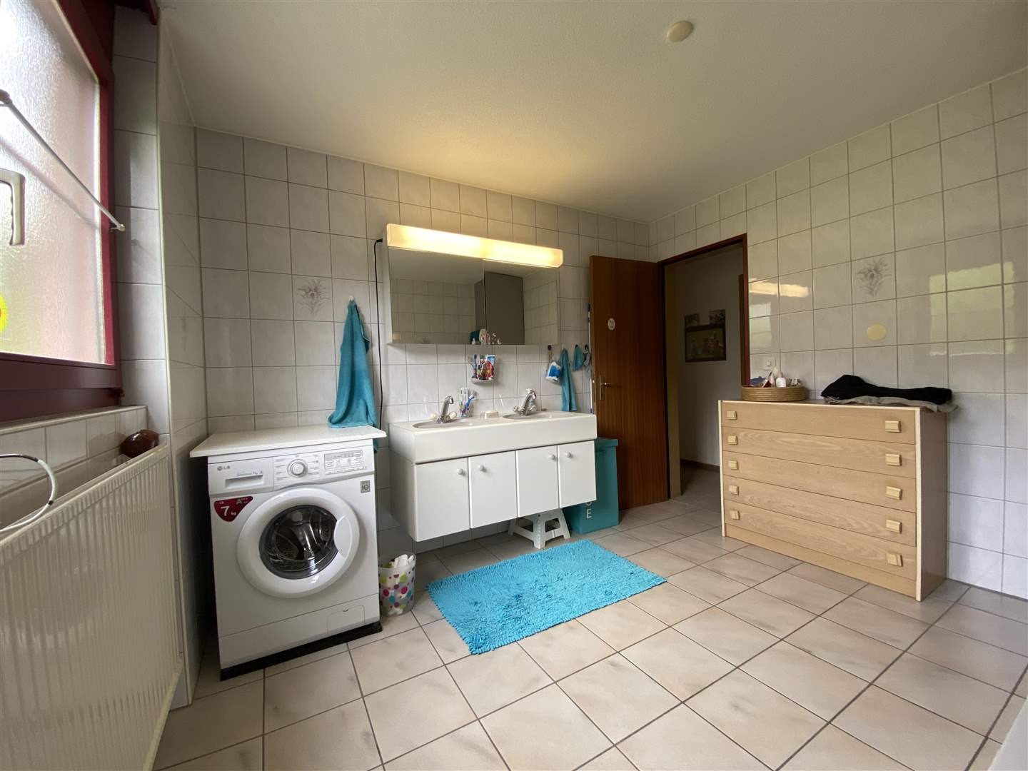 Badezimmer mit Waschmaschine und Doppelwaschtisch