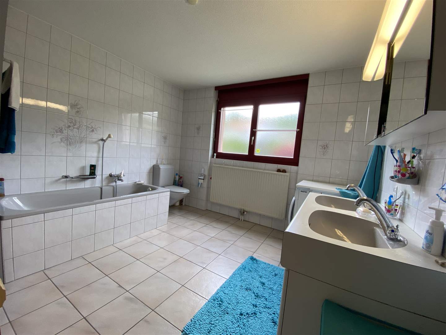 Helles Badezimmer mit Badewanne und Doppelwaschbecken