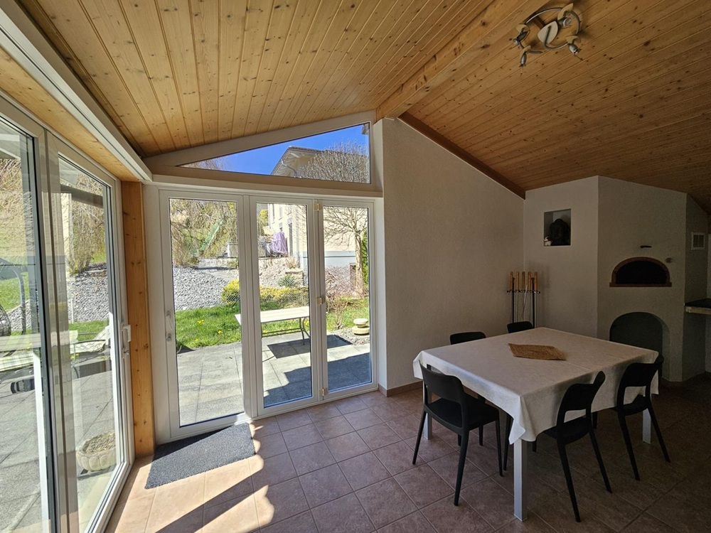 Esszimmer mit Holzdecke und Gartenblick