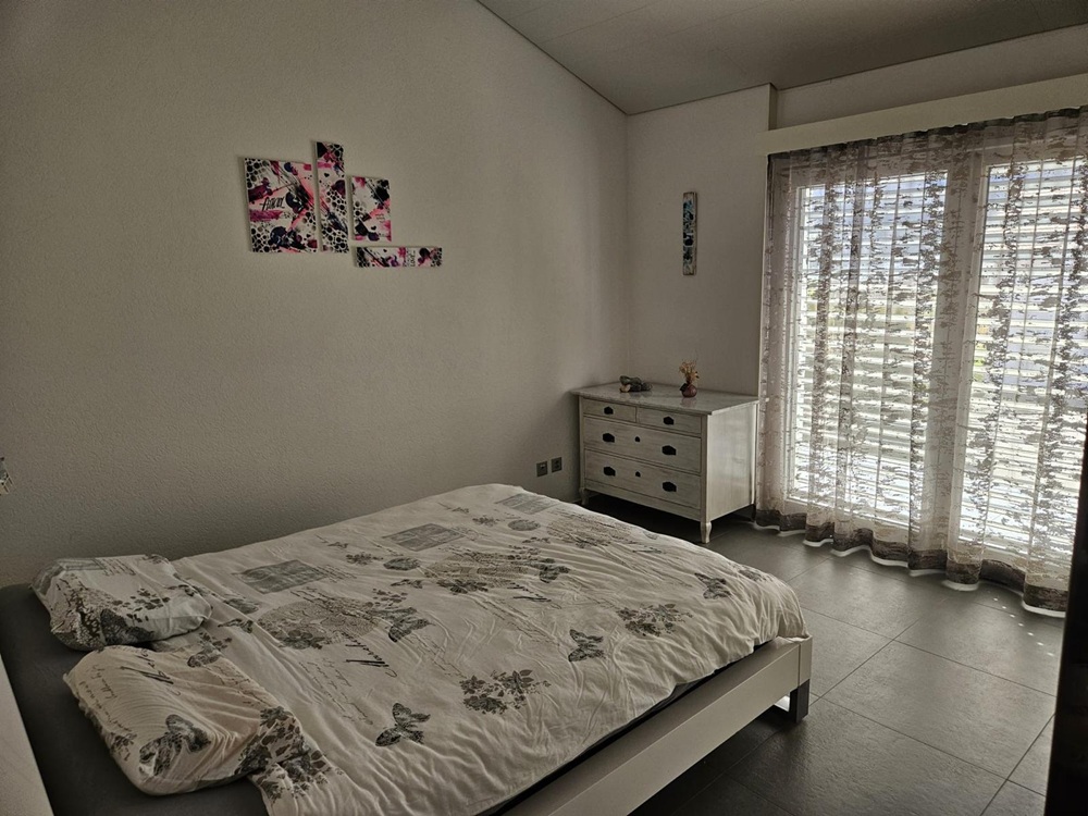 Schlafzimmer mit Tageslicht und schlichter Einrichtung