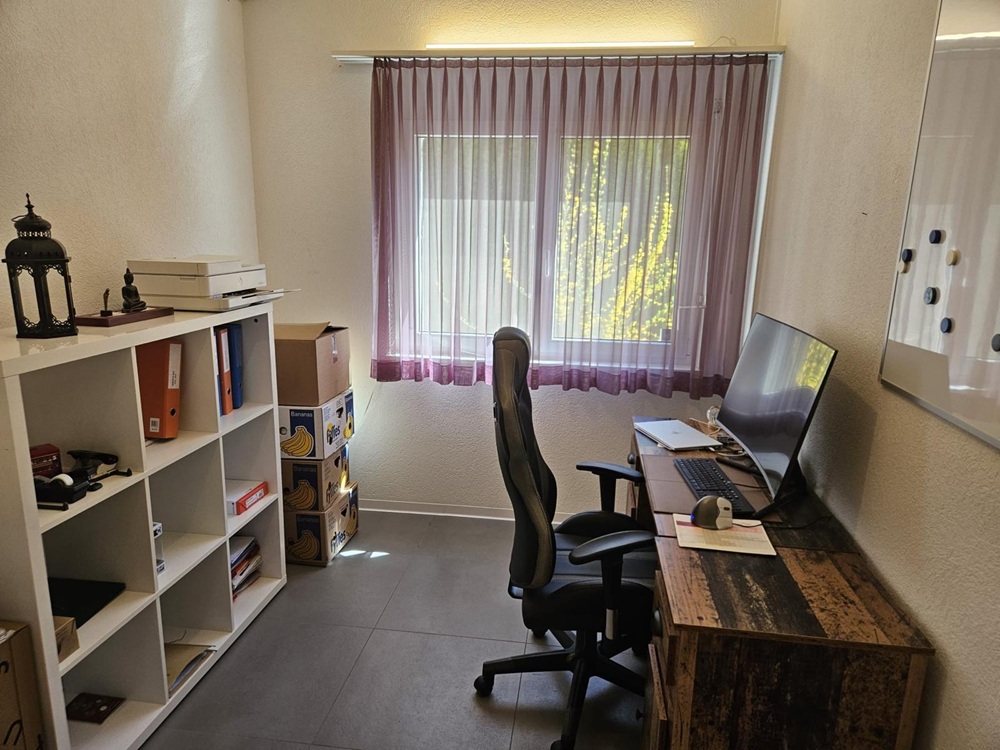 Arbeitszimmer mit Schreibtisch und Regal