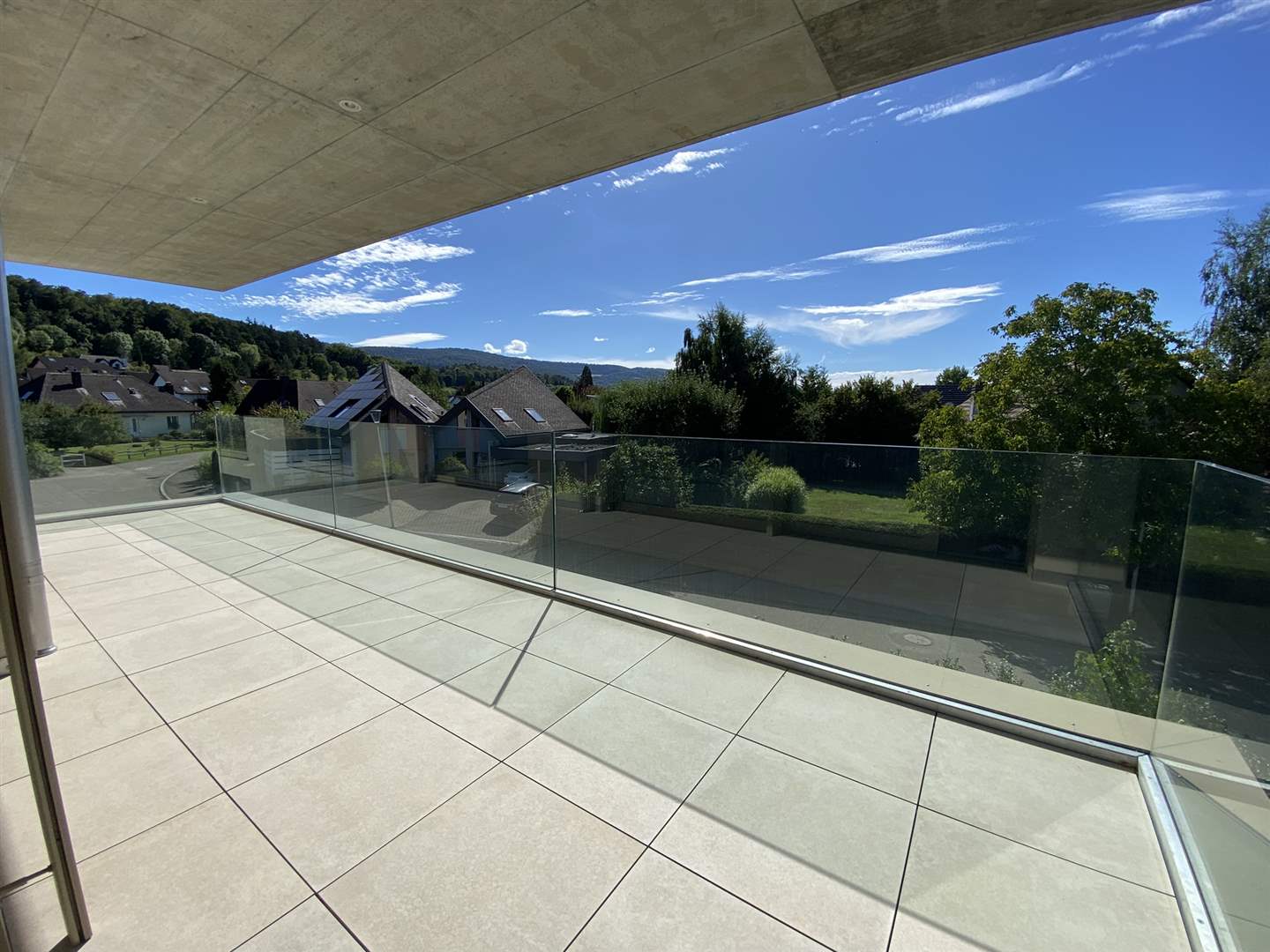 Große überdachte Dachterrasse mit Glasgeländer