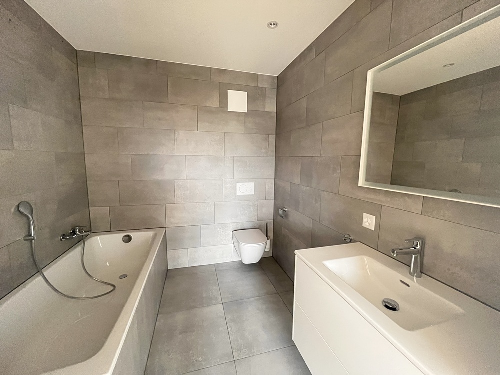 Modernes Badezimmer mit Badewanne, Doppelwaschbecken und Wand-WC