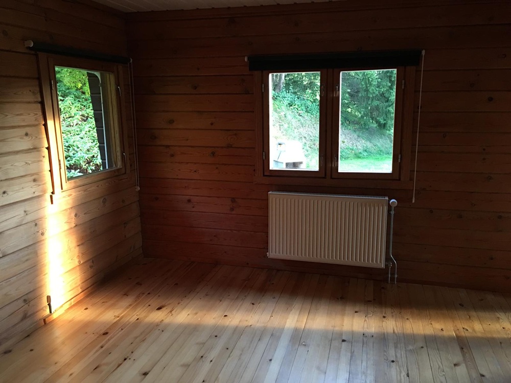 Holzverkleideter Raum mit Fenstern und Heizkörper