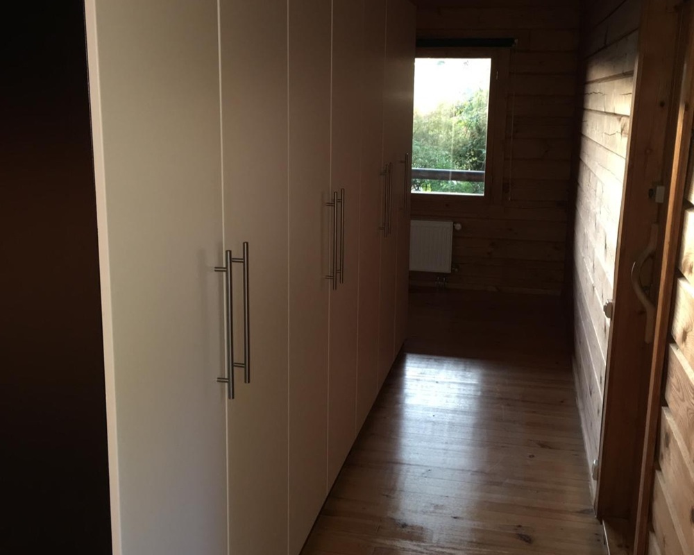 Flur mit Einbauschränken und Holzwand