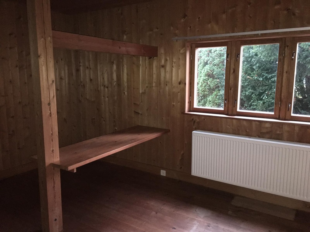 Holzverkleideter Raum mit Fenster und Heizkörper