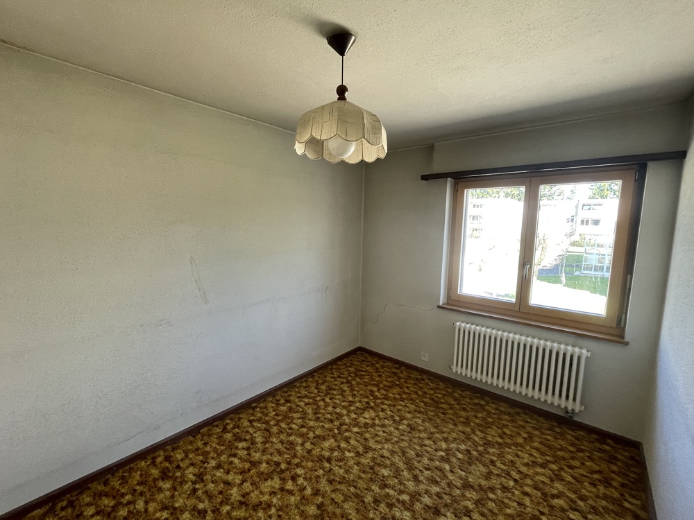 Kleines Zimmer mit Retro-Teppich und Holzfenster