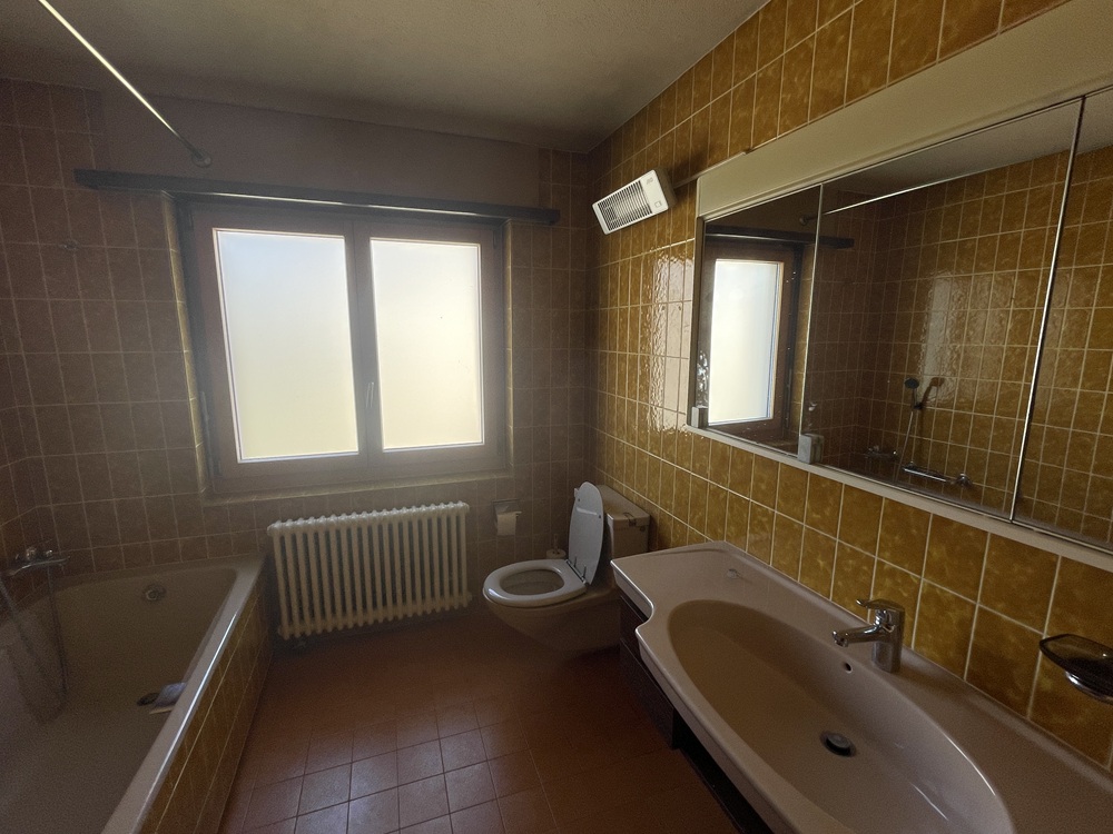 Dunkles Badezimmer mit gelben Wandfliesen