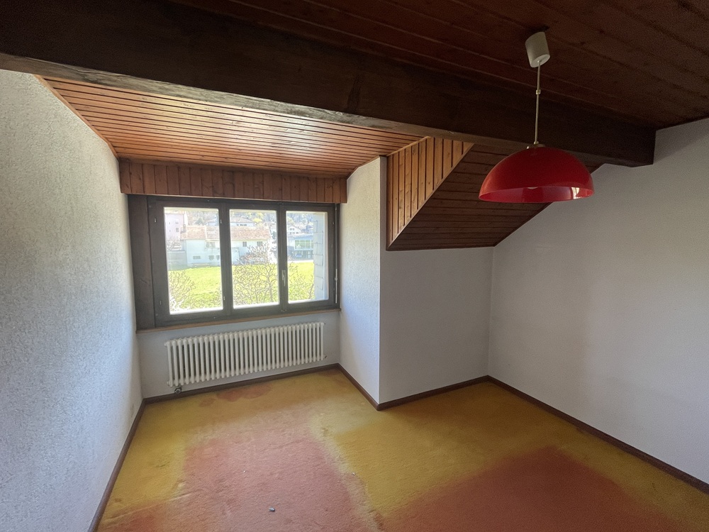 Kleines Zimmer mit Holzdecke und Fenster