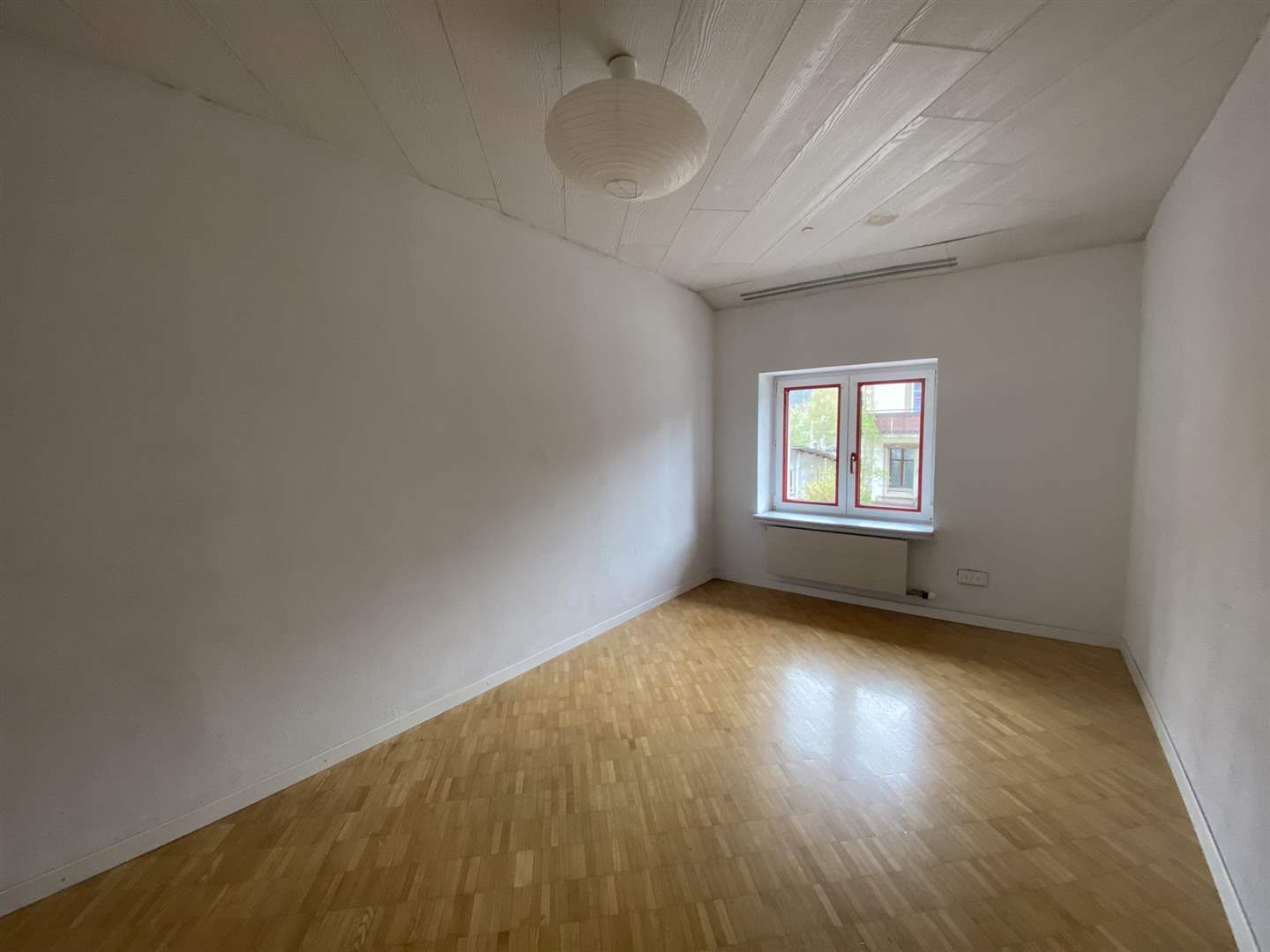 Leeres Zimmer mit Holzfußboden und Fenster