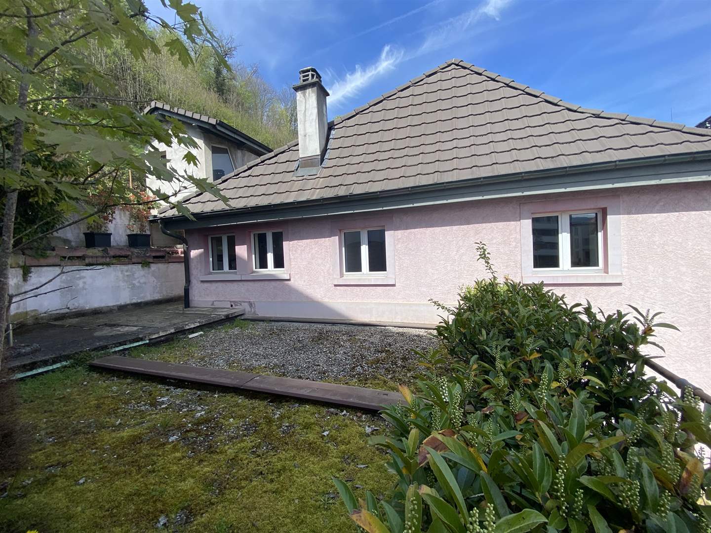 Ein eingeschossiges Wohnhaus mit Satteldach und kleinem Innenhof/Garten