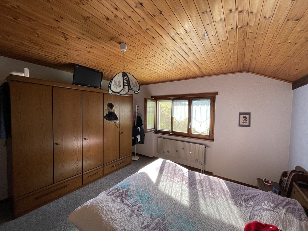 Schlafzimmer mit Holzdecke und Kleiderschrank
