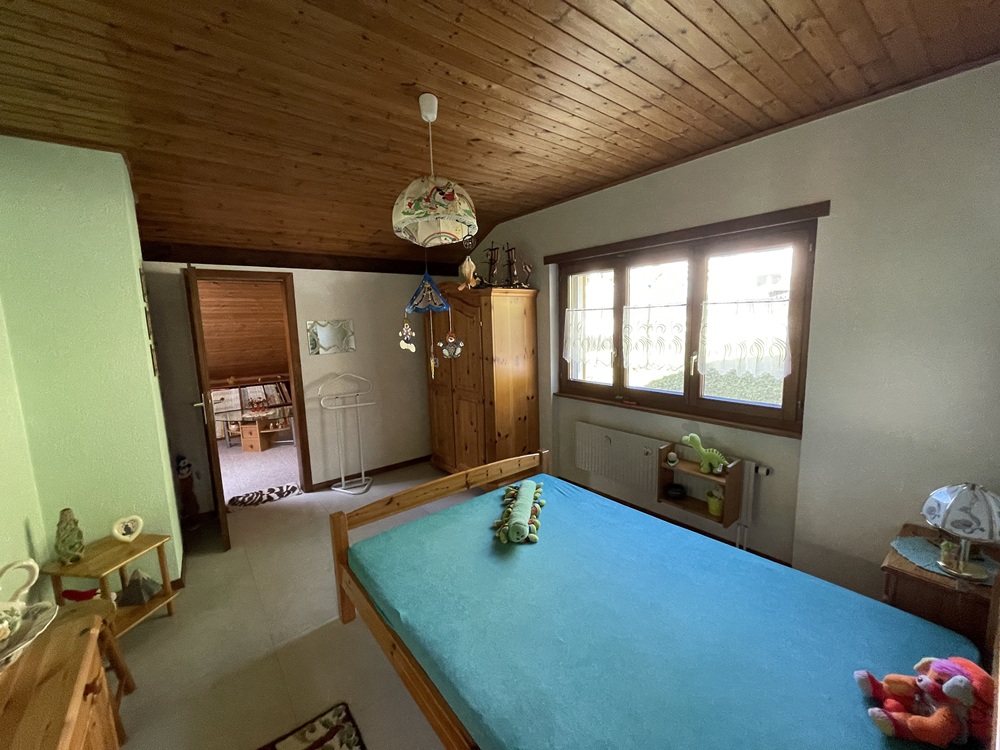 Kinderzimmer mit Holzdecke und Einzelbett
