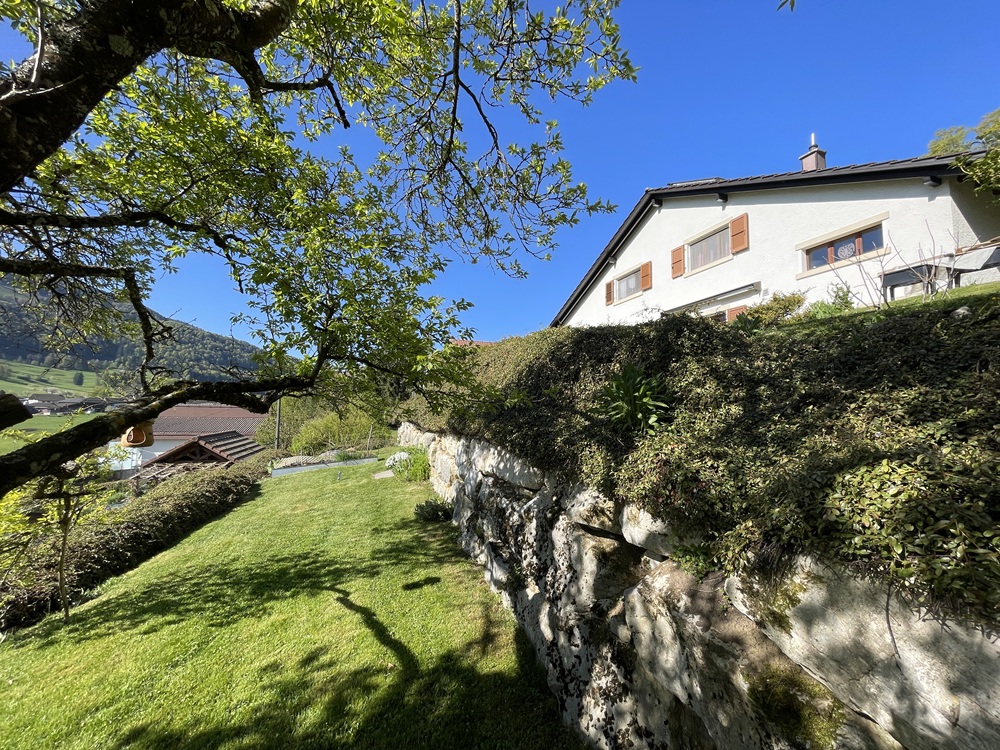 Gartenansicht mit Einfamilienhaus am Hang