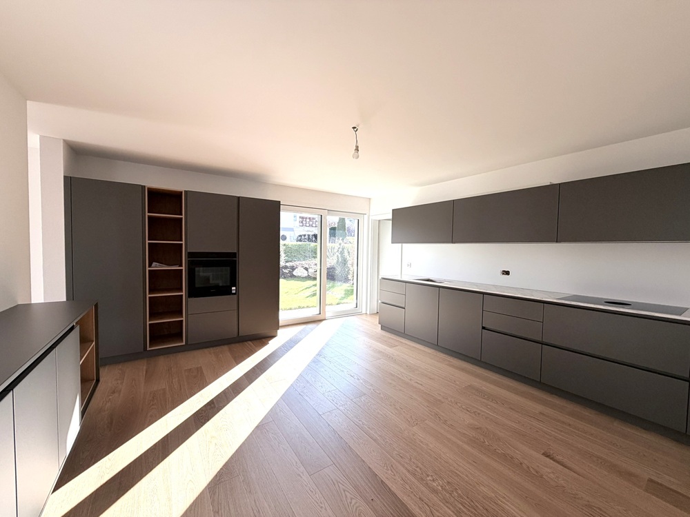 Moderne Küche mit großen Fronten und Gartenausblick