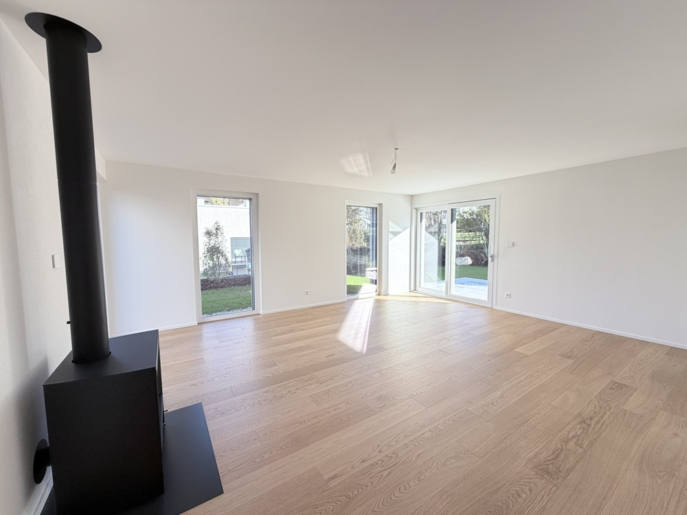 Heller Wohnraum mit Kaminofen und Terrassenzugang