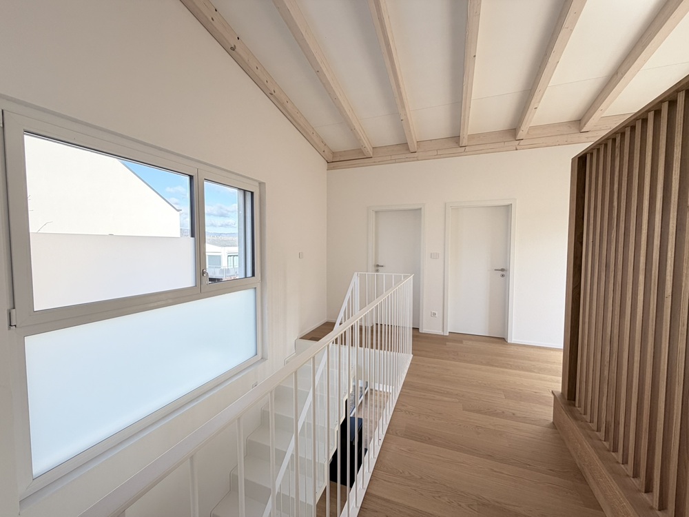 Heller Galerieflur mit Treppe und Holzdecke