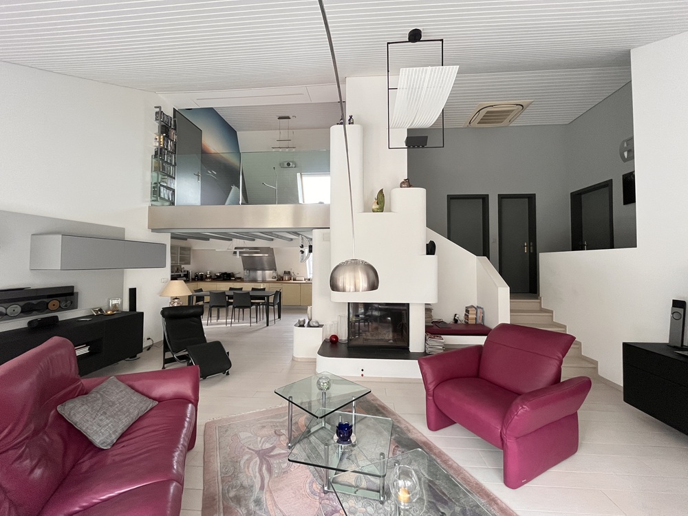 Großzügiges Wohn-Esszimmer mit Kamin und Galerie