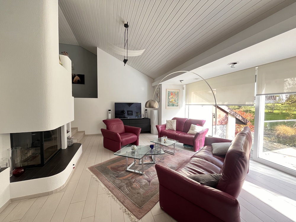 Heller Wohnraum mit Kamin und Blick in den Garten