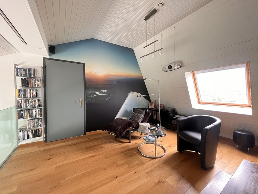Dachgeschosszimmer mit Panoramamotiv und Sitzbereich