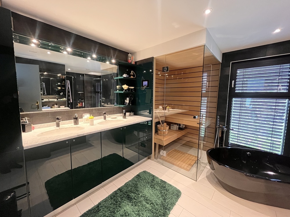 Modernes Badezimmer mit Sauna und schwarzer Wanne