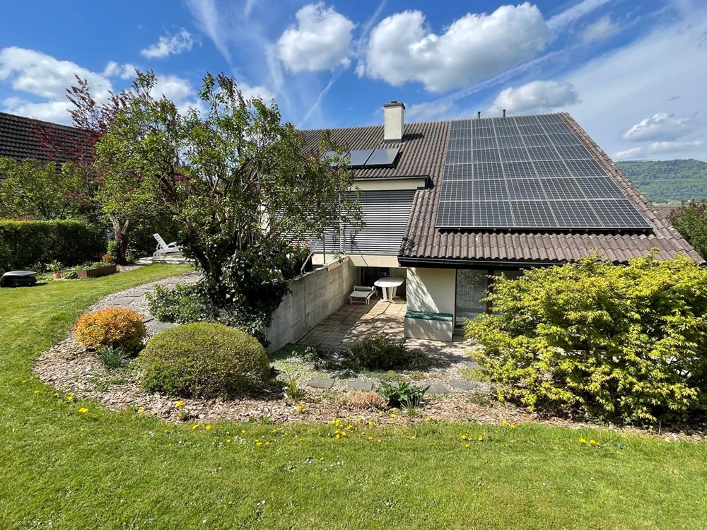 Gartenansicht eines Einfamilienhauses mit Solaranlage