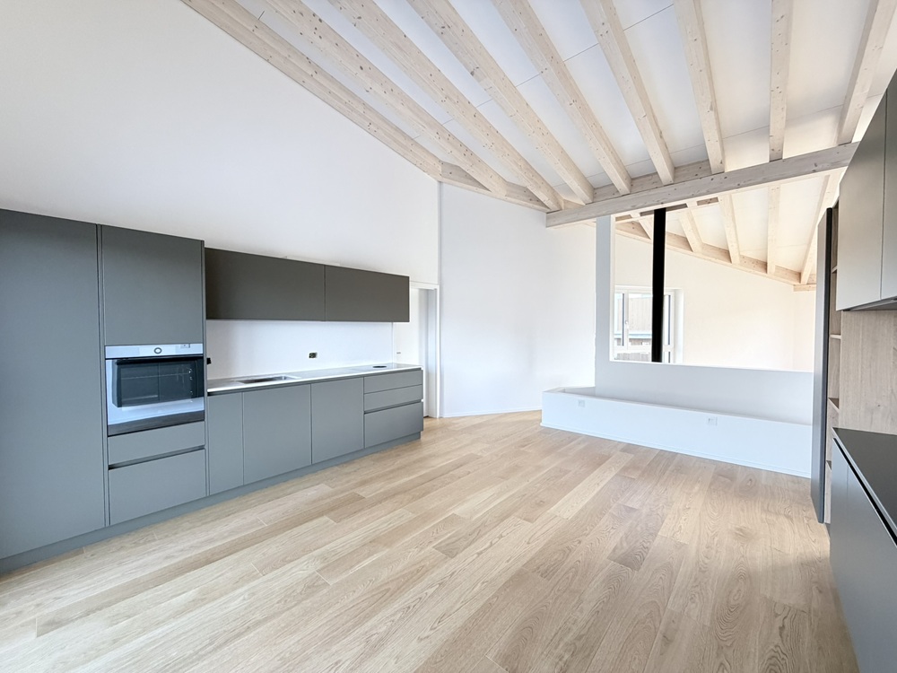 Moderne Dachgeschossküche mit sichtbaren Holzbalken