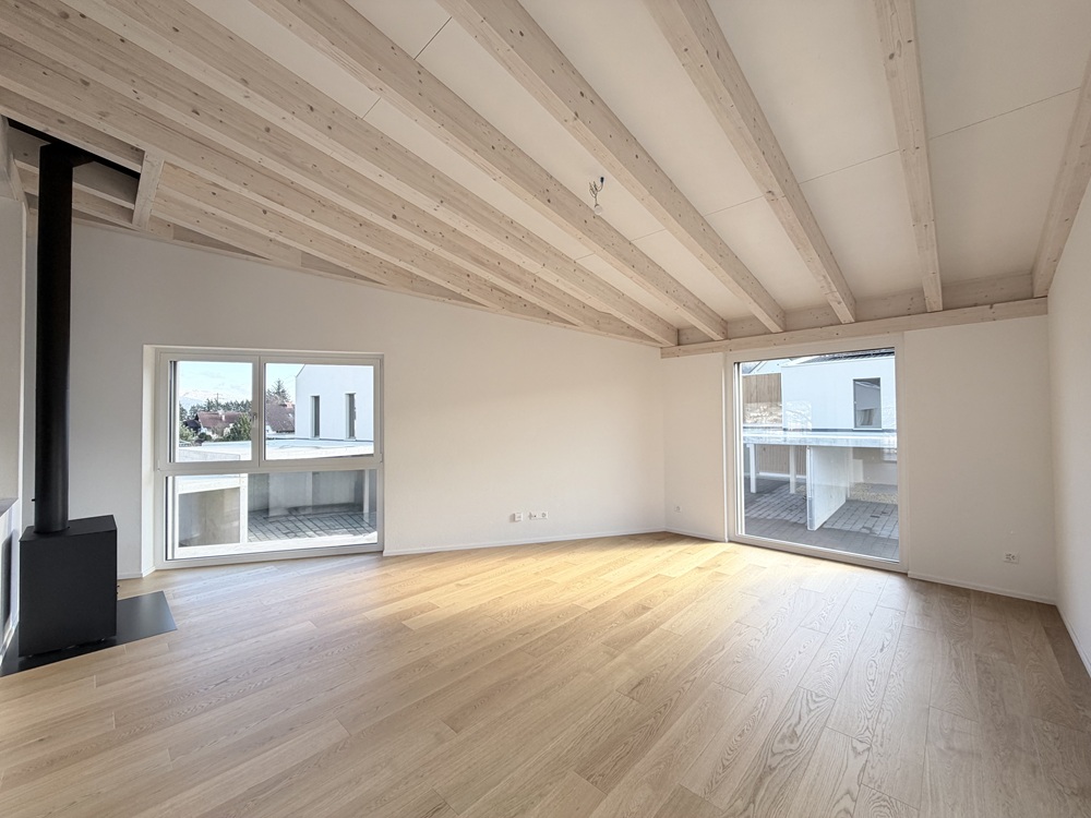 Heller Wohnraum mit sichtbarer Holzbalkendecke