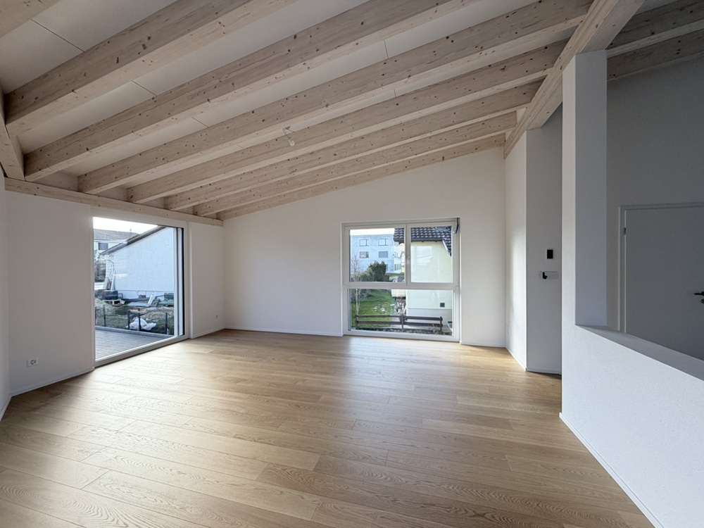 Offener Wohnraum mit Holzdecke und Eichenboden