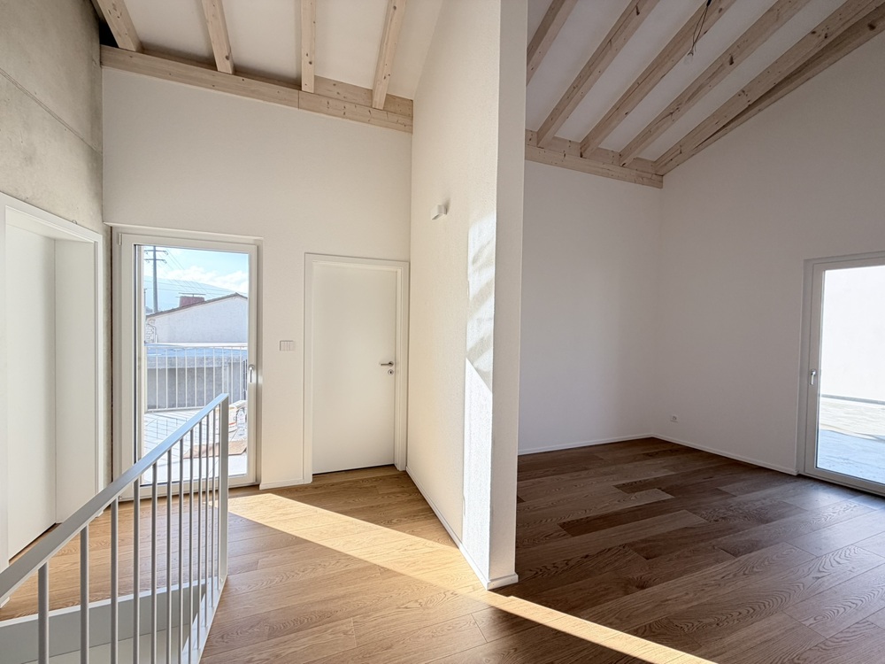 Heller Flur mit Holzdecke und Balkonzugang