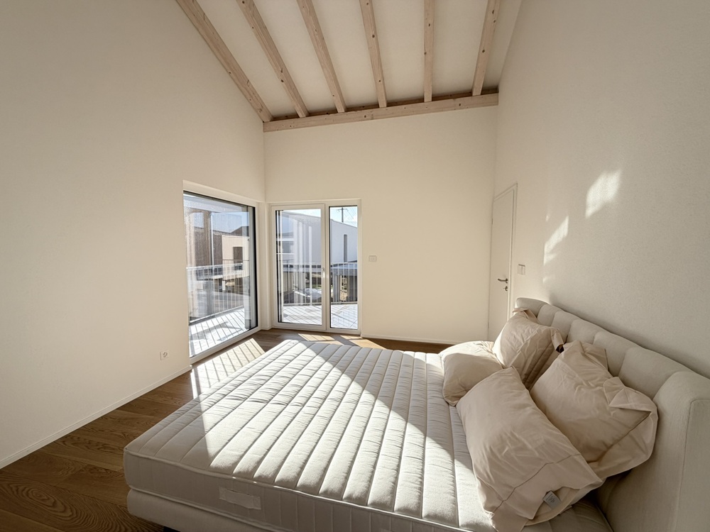 Helles Schlafzimmer mit hohen Decken und Balkonzugang