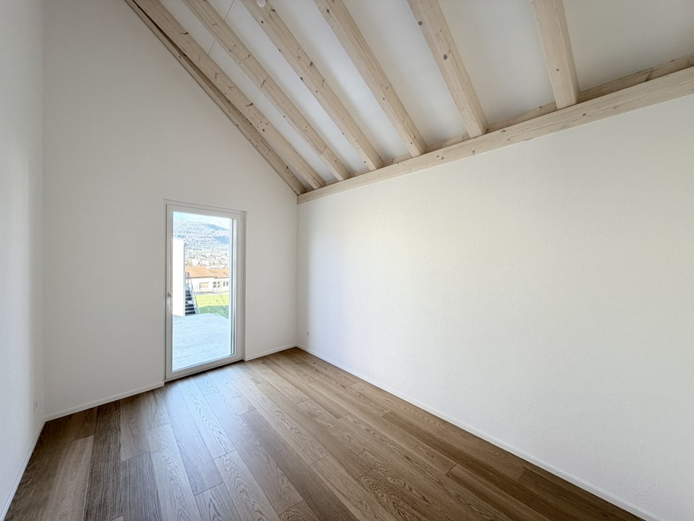 Heller leerer Raum mit sichtbaren Holzbalken