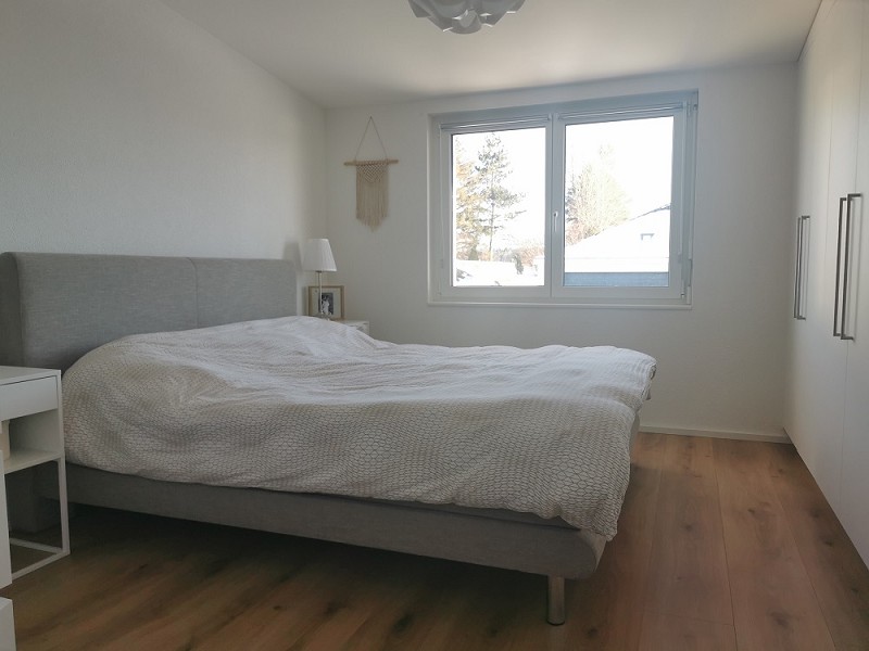 Helles Schlafzimmer mit Doppelbett und Fenster