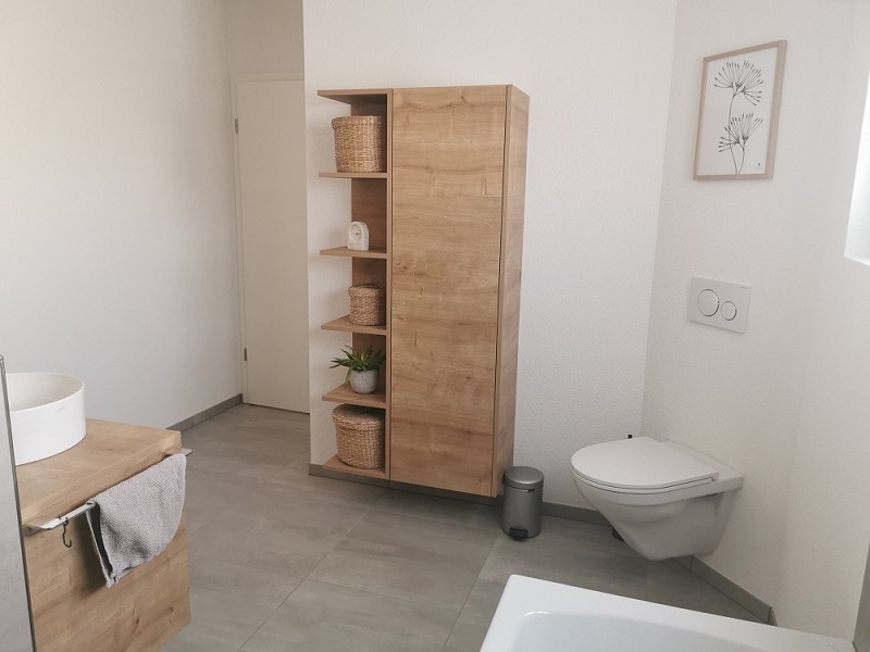 Modernes Badezimmer mit Holzoptik und wandhängendem WC