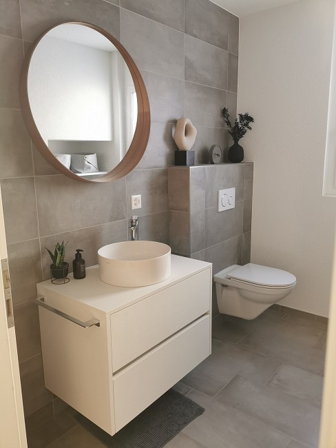 Modernes Gäste-WC mit rundem Spiegel