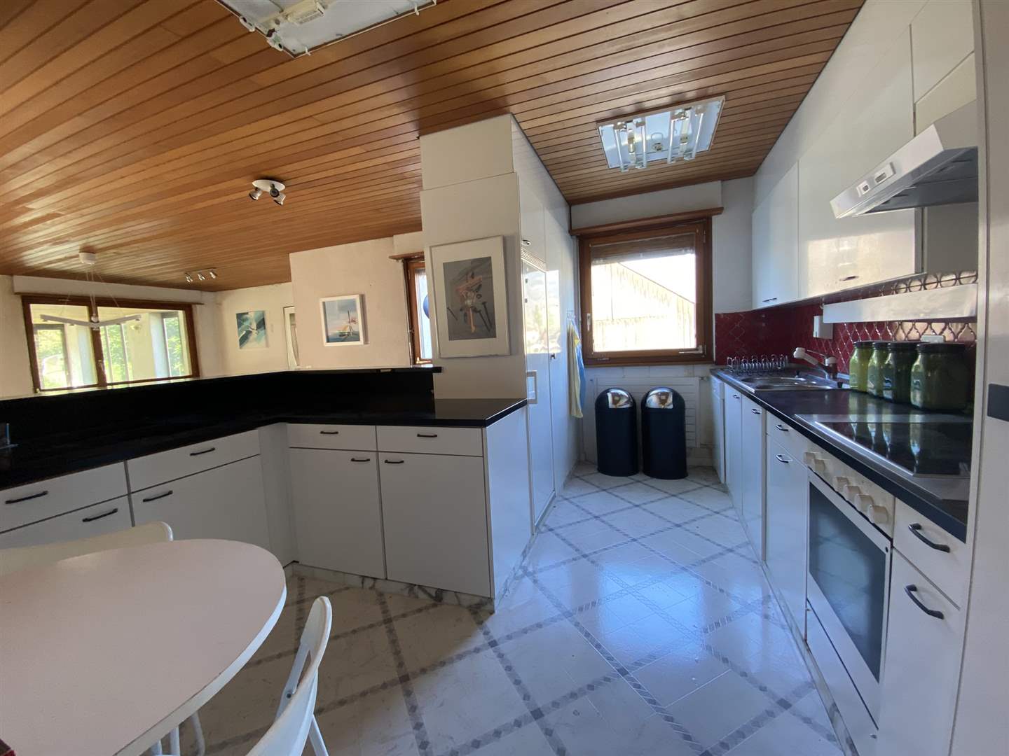 Küche mit Holzdecke und heller Einbauküche