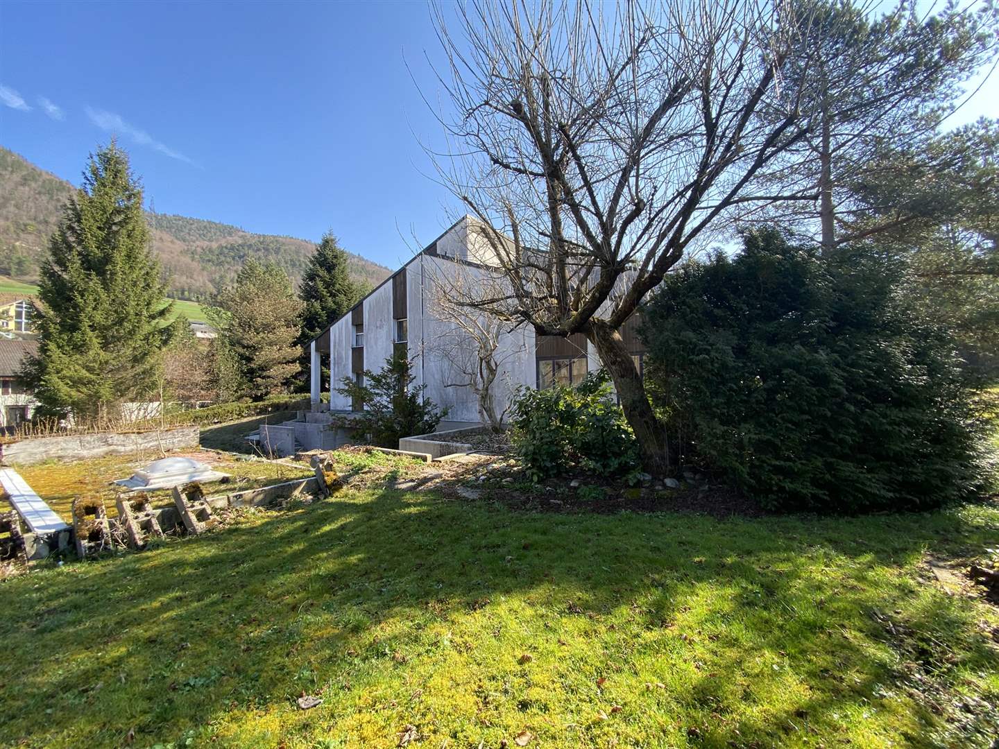 Modernes Haus mit Garten und Bergkulisse