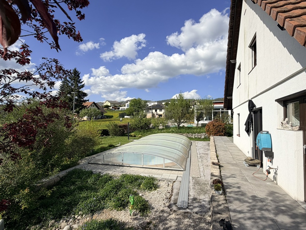 Gartenansicht mit Hausseite und Poolabdeckung