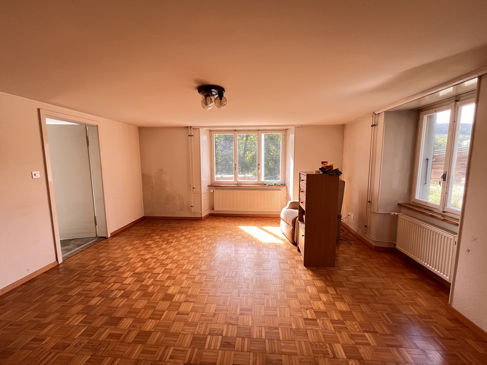 Leeres Wohnzimmer mit Parkett und Fenstern