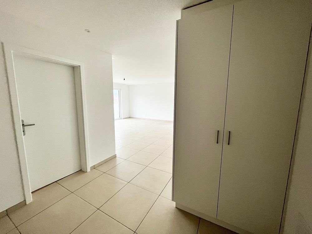 Heller Eingangs- oder Wohnbereich mit Fliesenboden und Einbauschrank