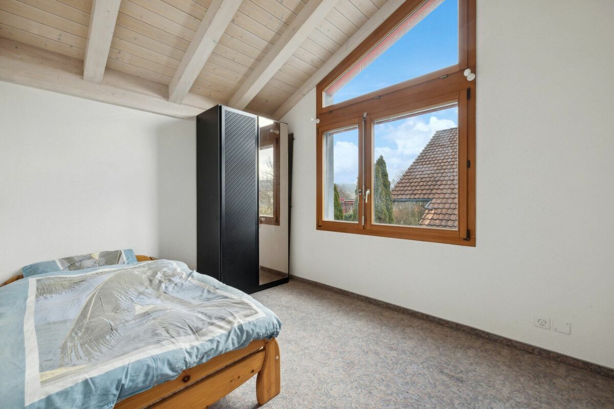 Schlafzimmer mit Dachschräge und großem Fenster