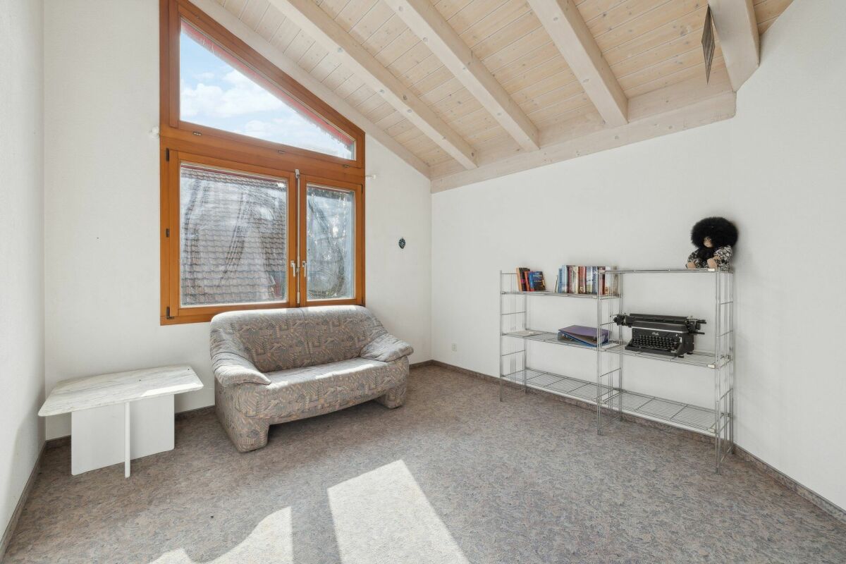 Heller Raum mit Dachschrägen und großer Holzverglasung